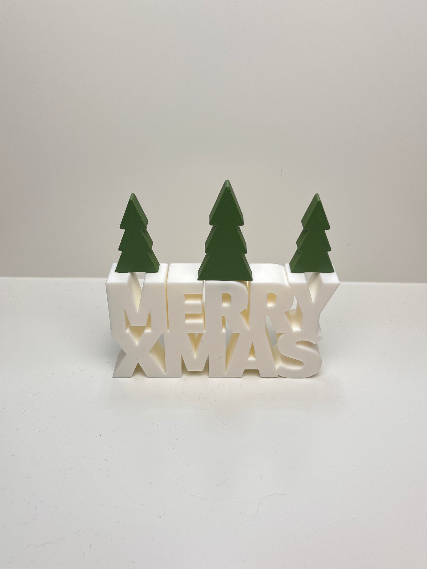 3D-gedrucktes „MERRY XMAS“ Dekoschild mit Tannenbäumen